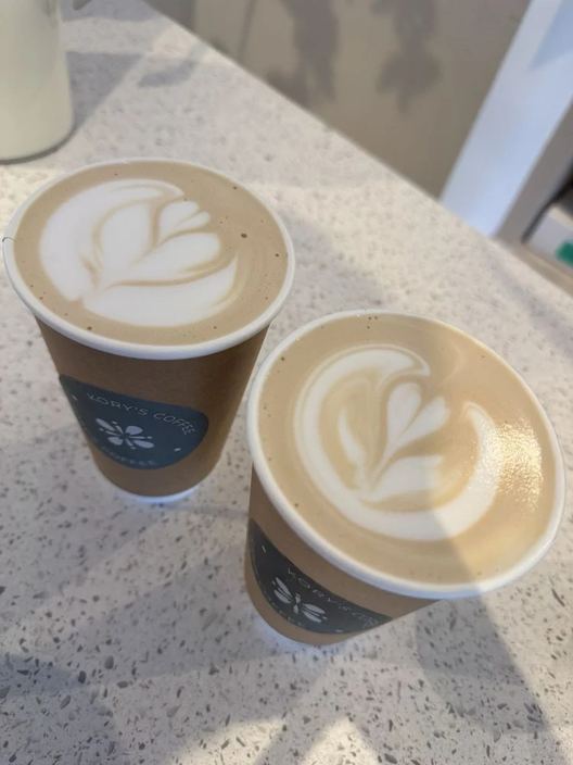 Two Kory’s Coffee cups side by side, each finished with a rosetta poured in the milk